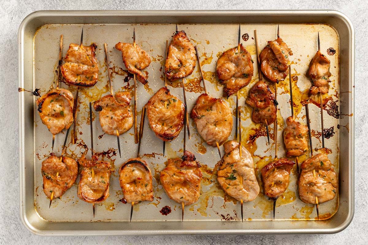 Taste of Home Pork Satay recipe photo of the skewered pork broiled on a baking sheet.