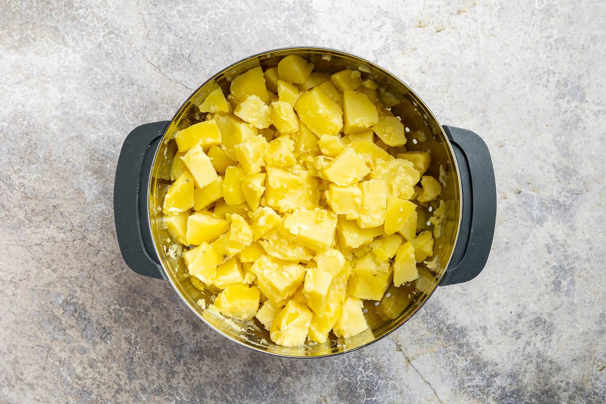 Taste of Home Russian Potato Salad recipe photo of the cooked potatoes draining in a colander.