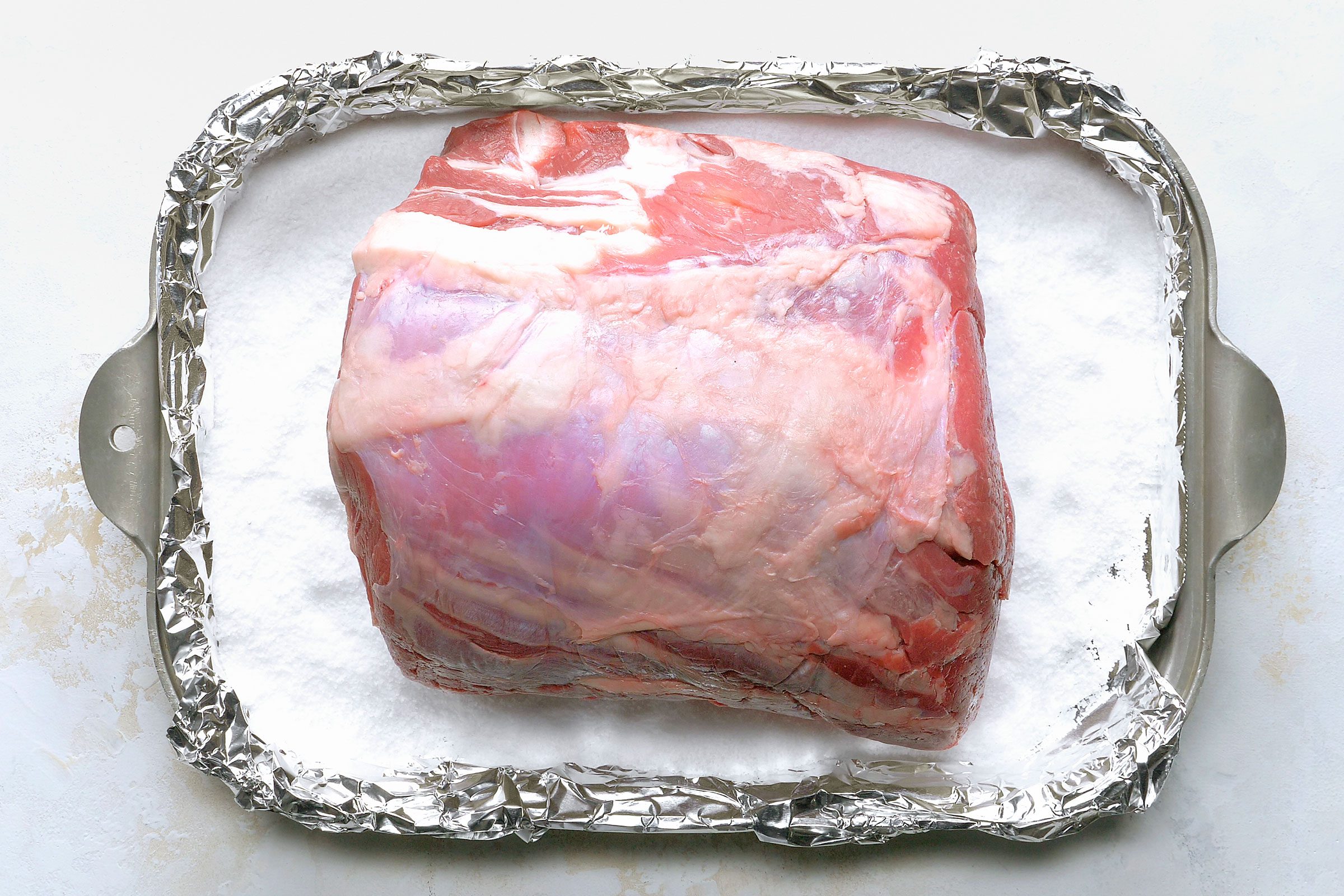 Prime rib on a foiled pan with kosher salt on it