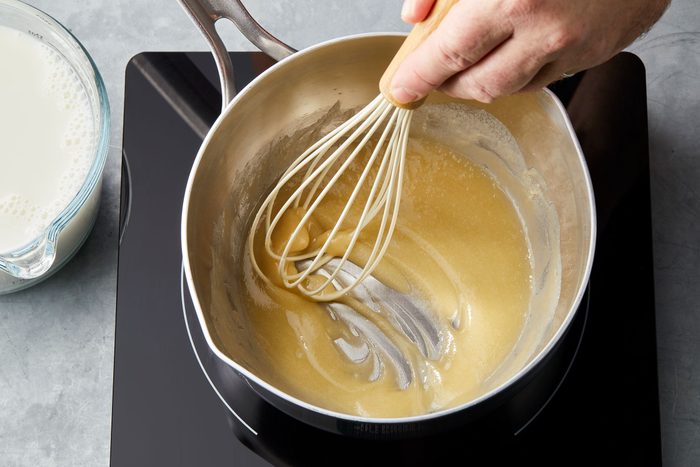 Flour being whisked into melted butter in a pan
