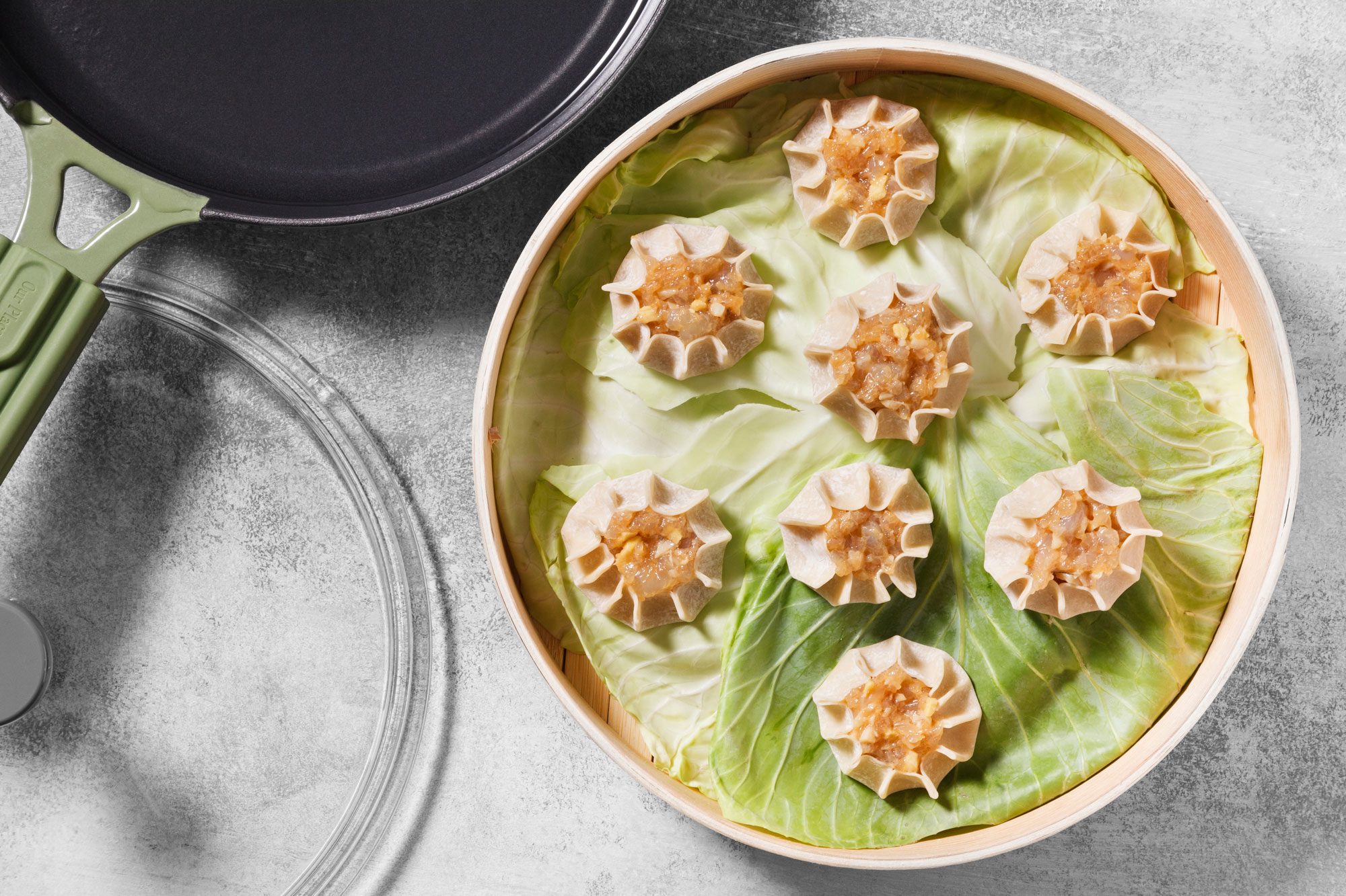 Line a steamer basket with three cabbage leaves. Arrange dumplings 1 in. apart over cabbage; p