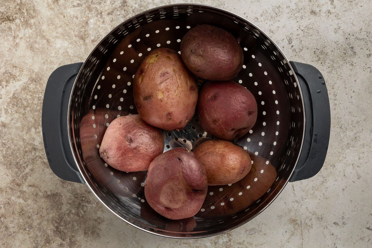 Taste of Home Sour Cream Potato Salad recipe photo of boiled potatoes in a colander.