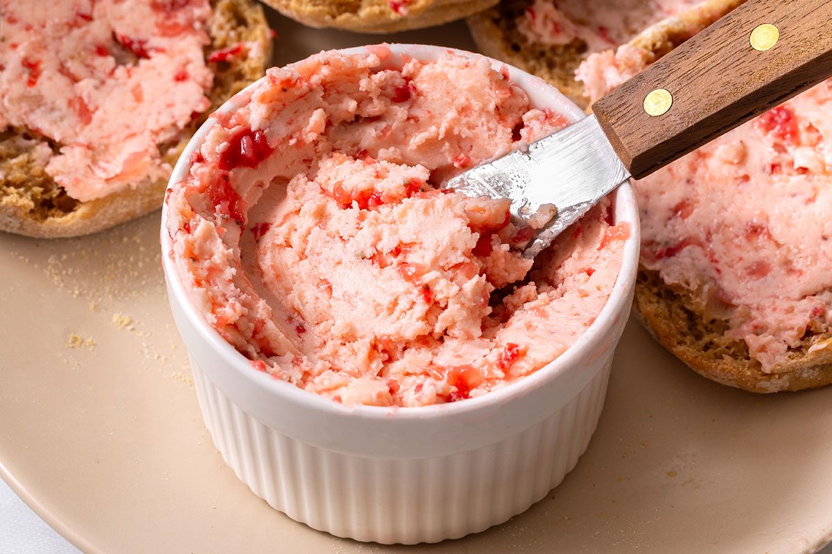 Strawberry Butter in a serving dish on a platter surrounded by buttered english muffins for Taste of Home
