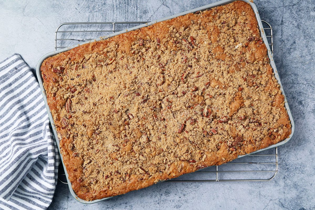 Process of making Taste of Home's Buttermilk Coffee Cake cooling on a wire rack on a light blue surface.