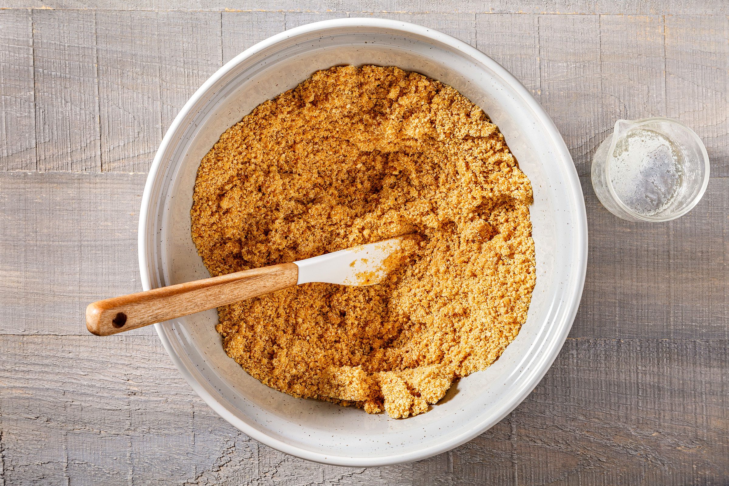 Graham cracker crumbs, butter and sugar mixed in a large bowl