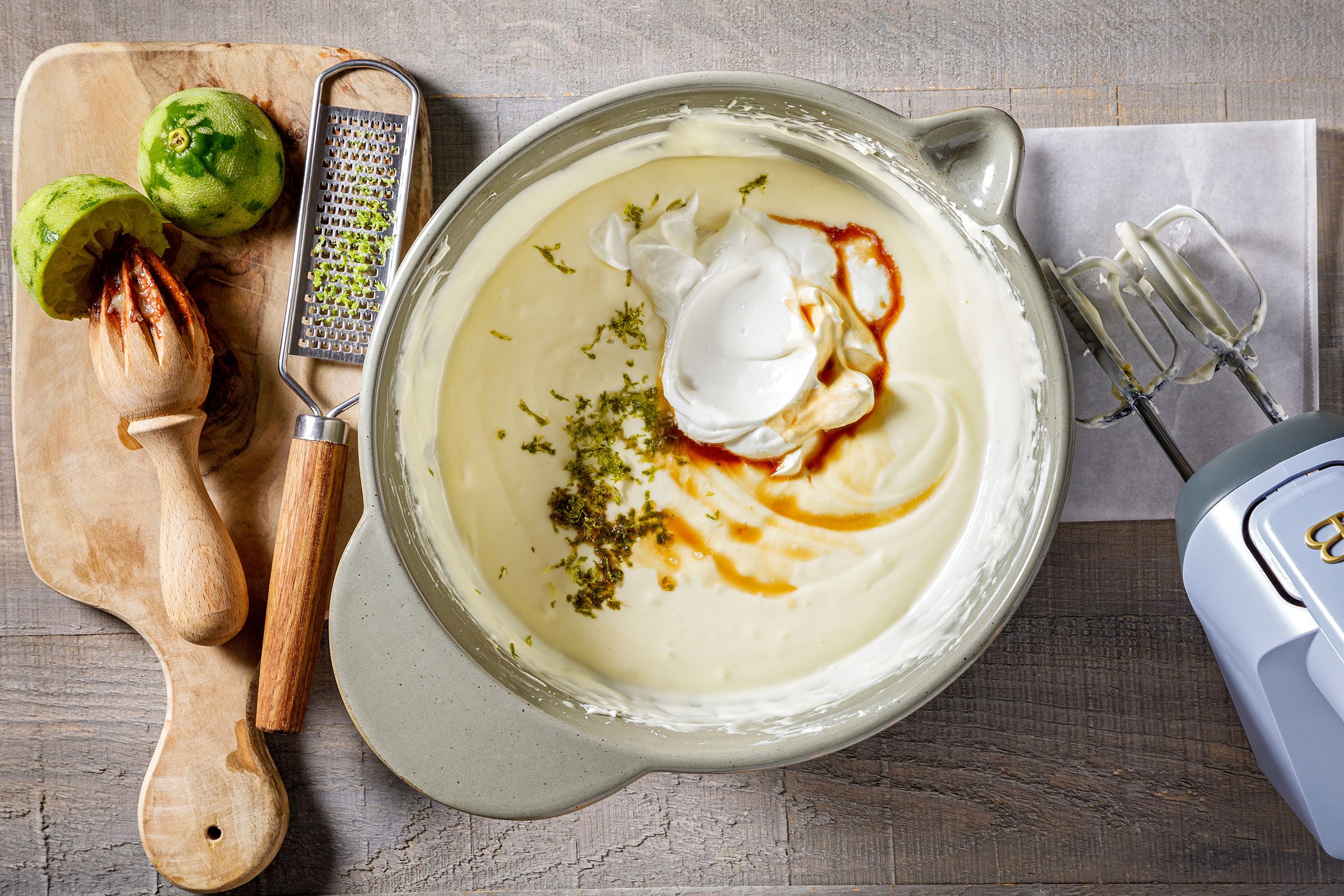 Adding lemon zest, sour cream and vanilla to the beaten egg and cream mixture