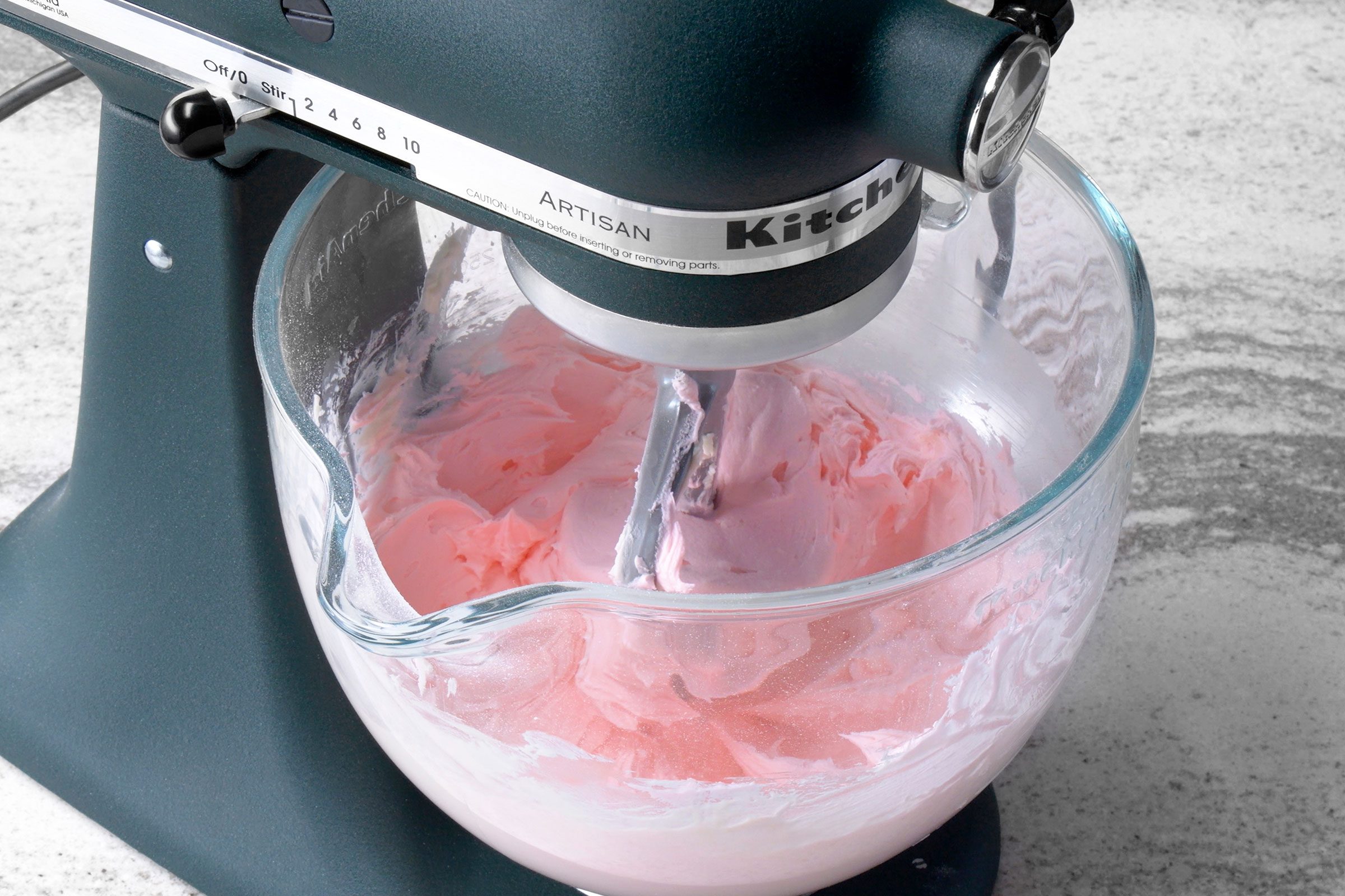 Pink colored cookie frosting mixed in a large bowl