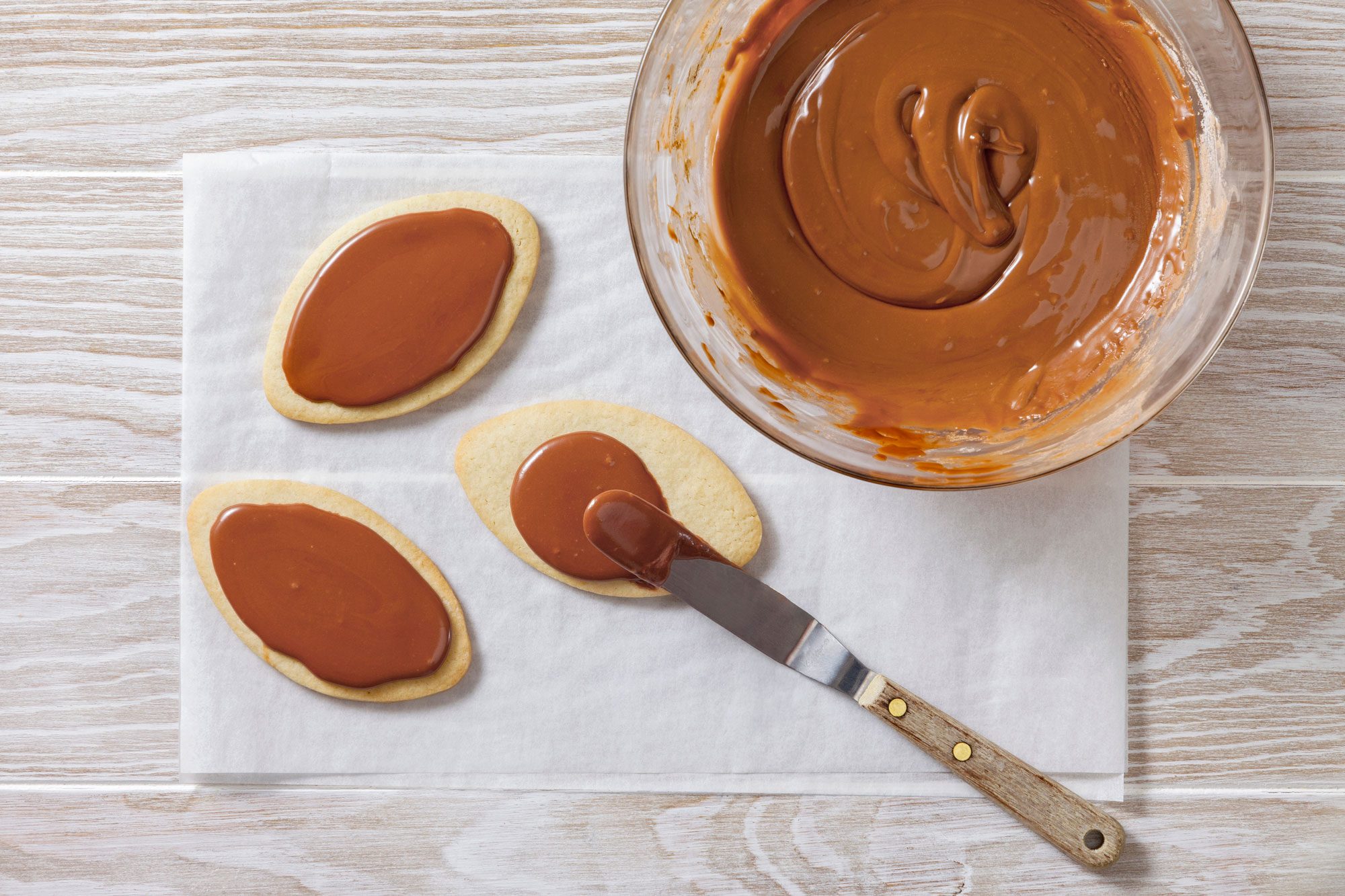 Pipe or spread brown icing on cooled cookies