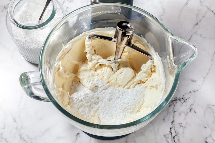 In a large bowl, beat together cream cheese and butter until soft and fluffy,