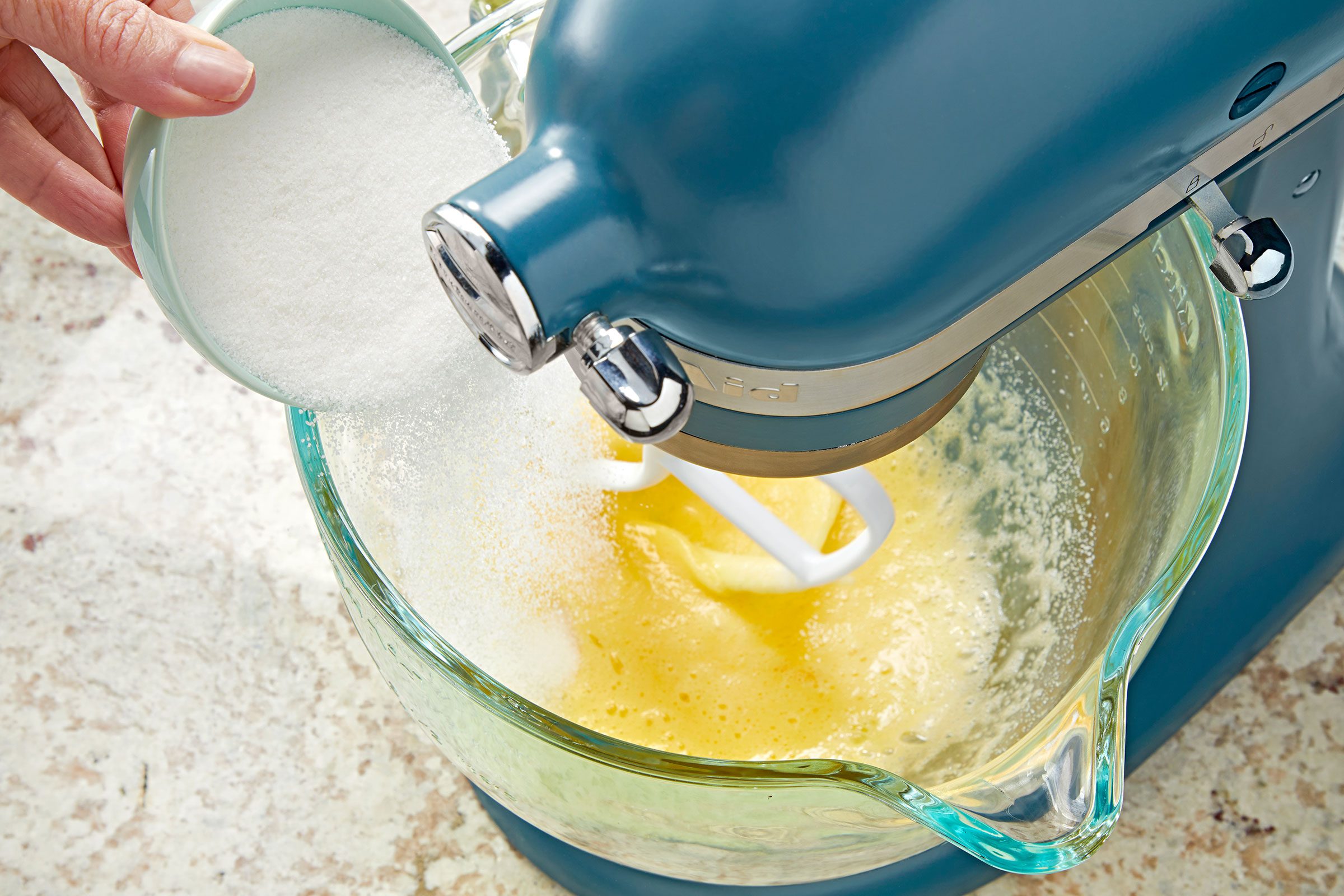 Adding sugar to the beaten eggs