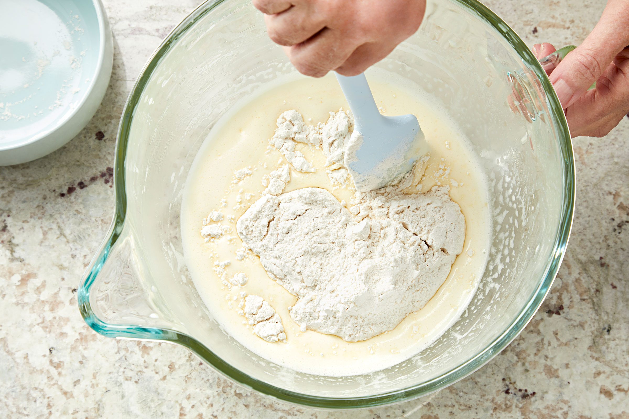 Folding dry ingredients for lemon olive oil cake in beaten eggs mixture