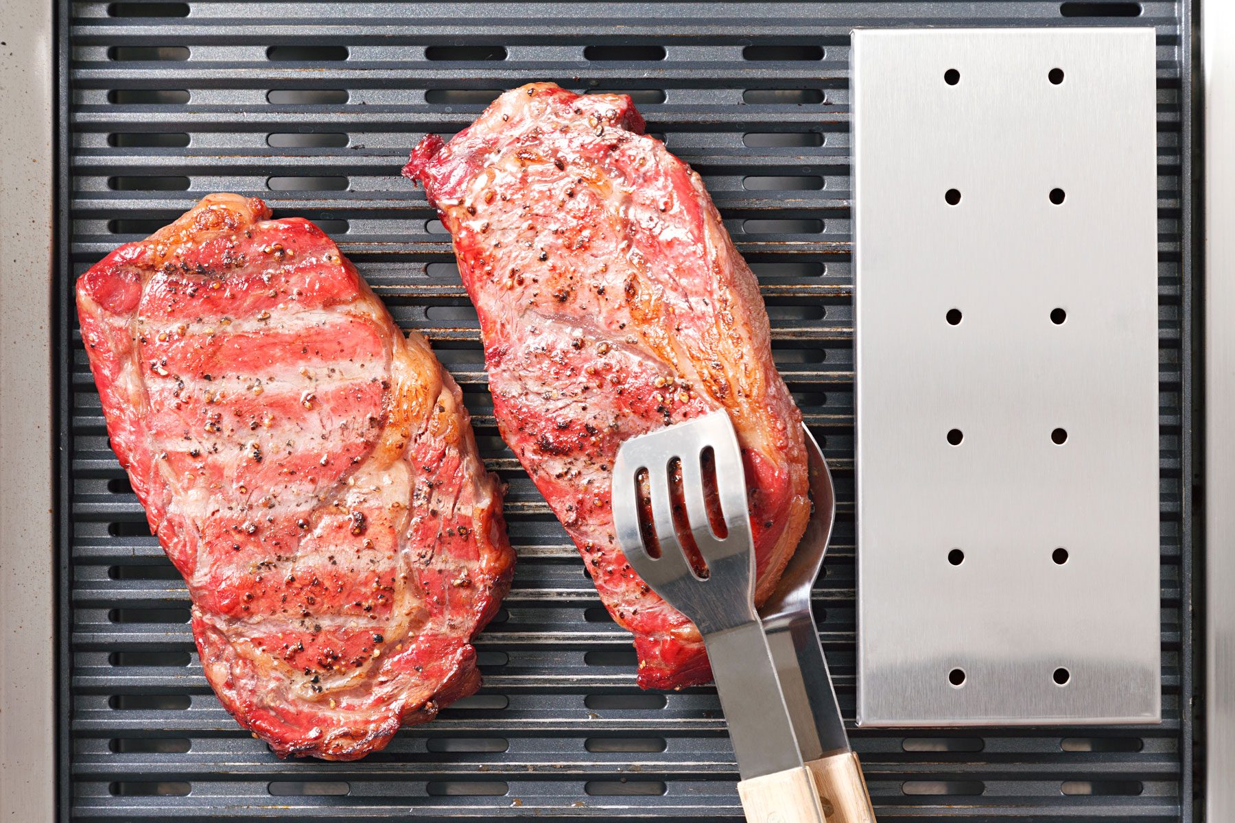 steaks being placed in smoker