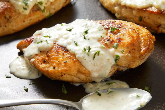 Close up shot of Chicken with Tarragon Sauce; Serve with chicken; Sprinkle with remaining tarragon; spoon; marble surface;