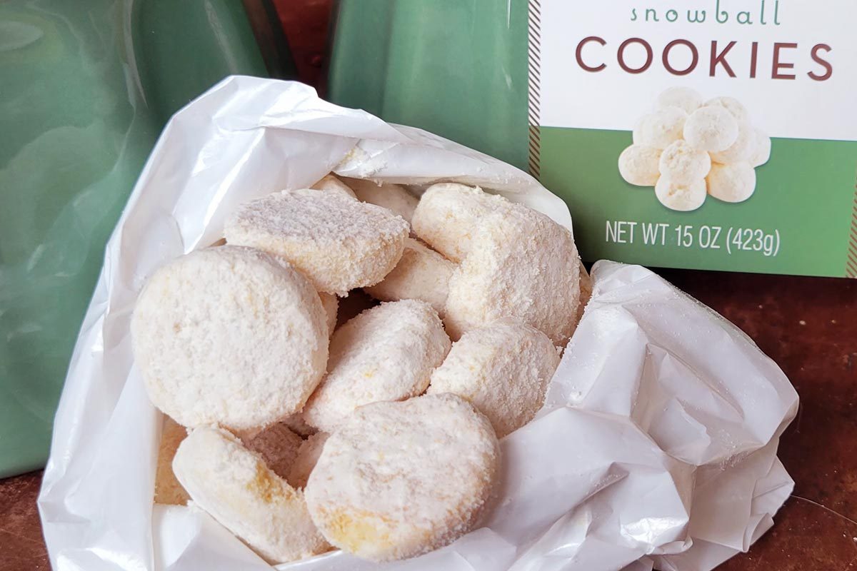A package of white circular cookies in front of a light creen box