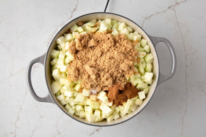 The pot is filled with diced apples, brown sugar, and cinnamon