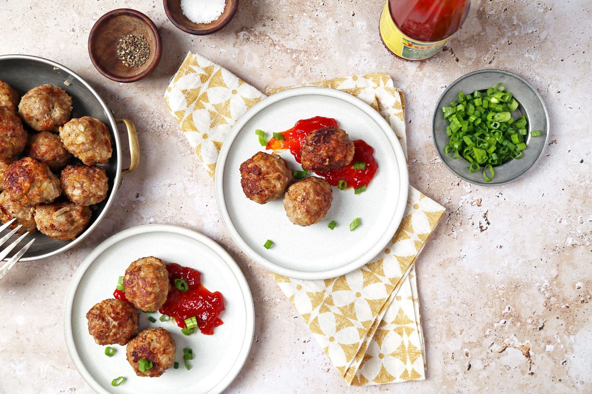Meatballs served on little stone plates with banana ketchup.