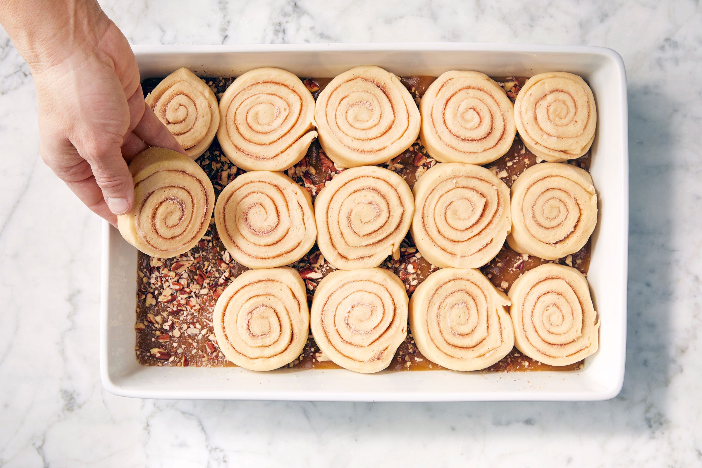 Log of dough cut into pieces and placed on caramel sauce in a dish