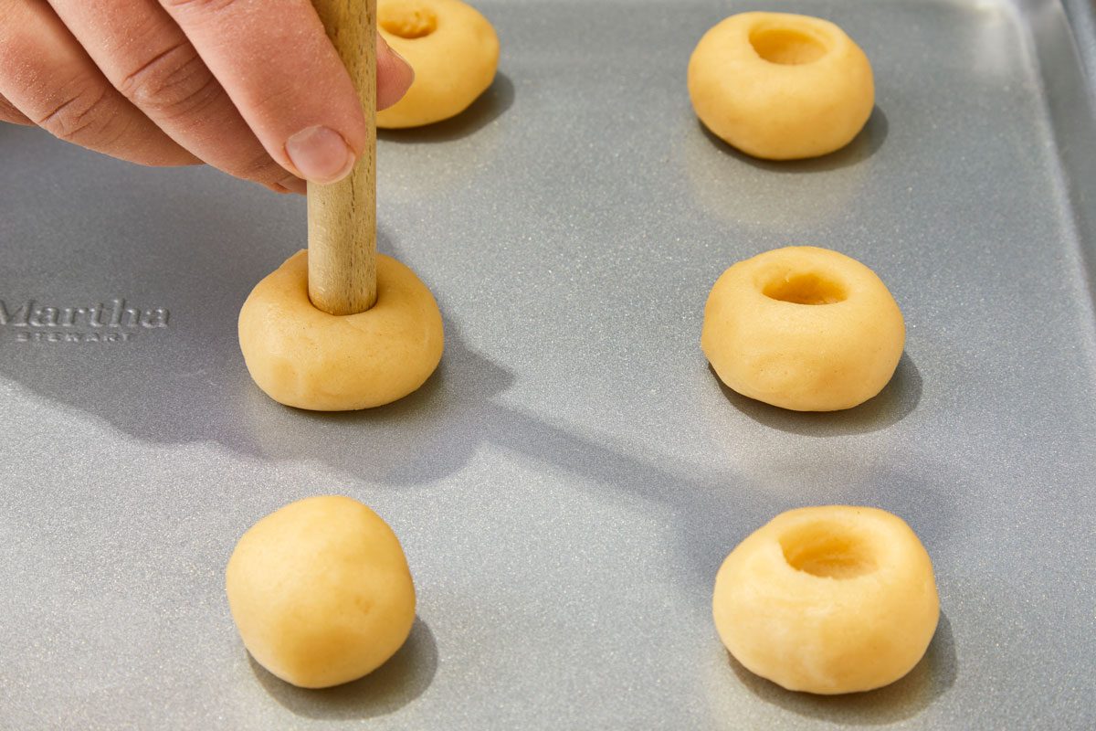 Using the end of a wooden spoon handle, make a 1/2-in.-deep indentation in the center of each ball;