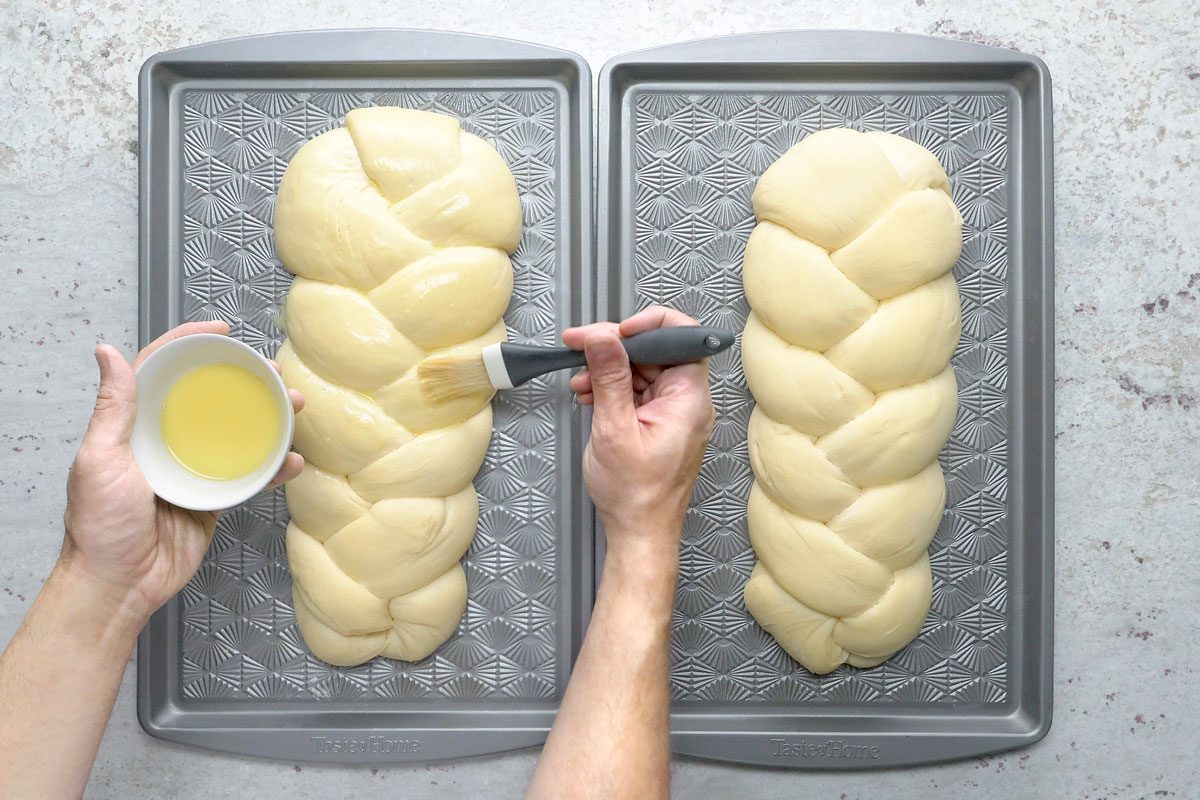 Overhead shot of brush over loaves; Sprinkle with sesame seeds; bake until golden brown 30-35 minutes; remove from pans to wire racks to cool; grey surface;