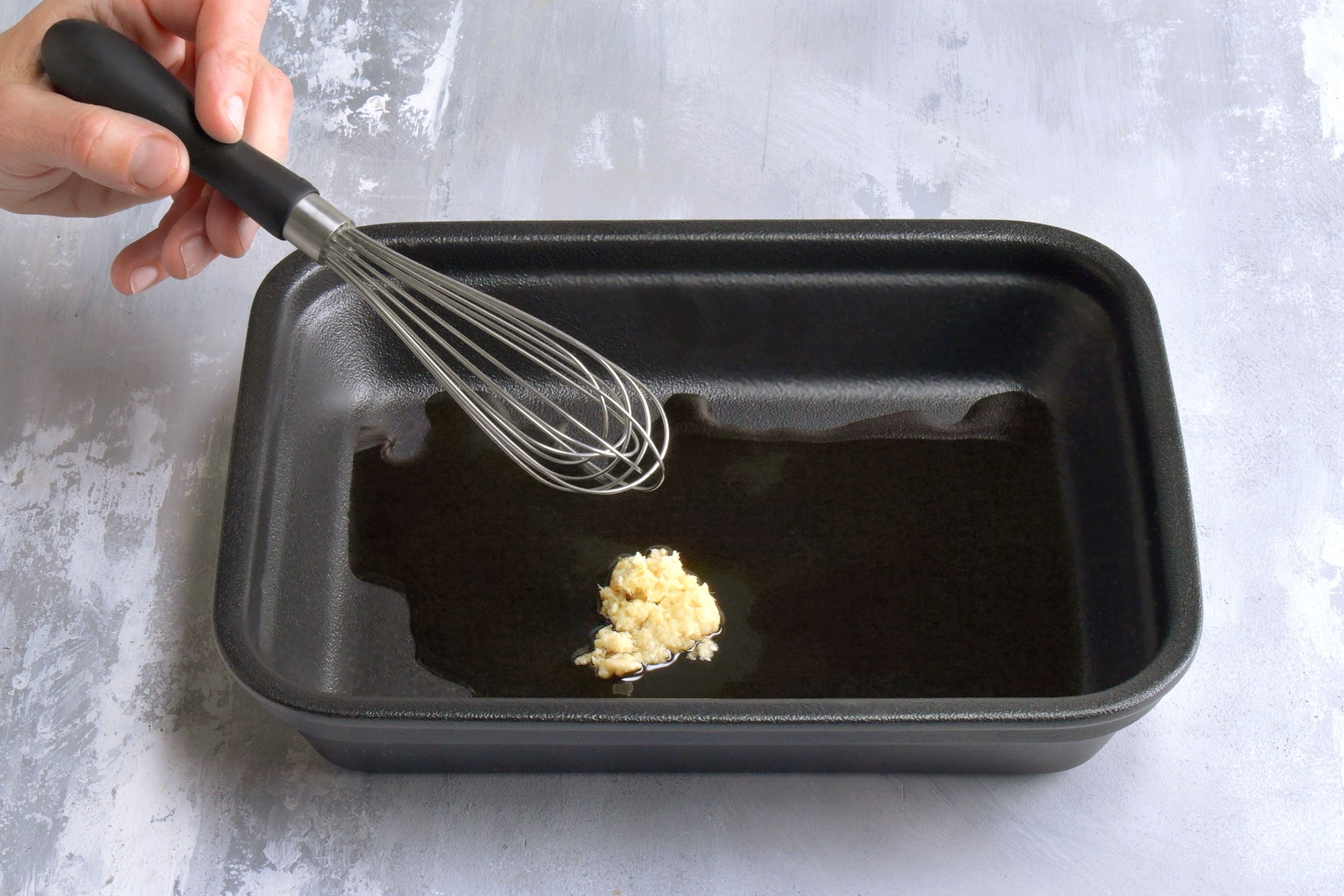 Sake, soy sauce, mirin and ginger in a shallow dish