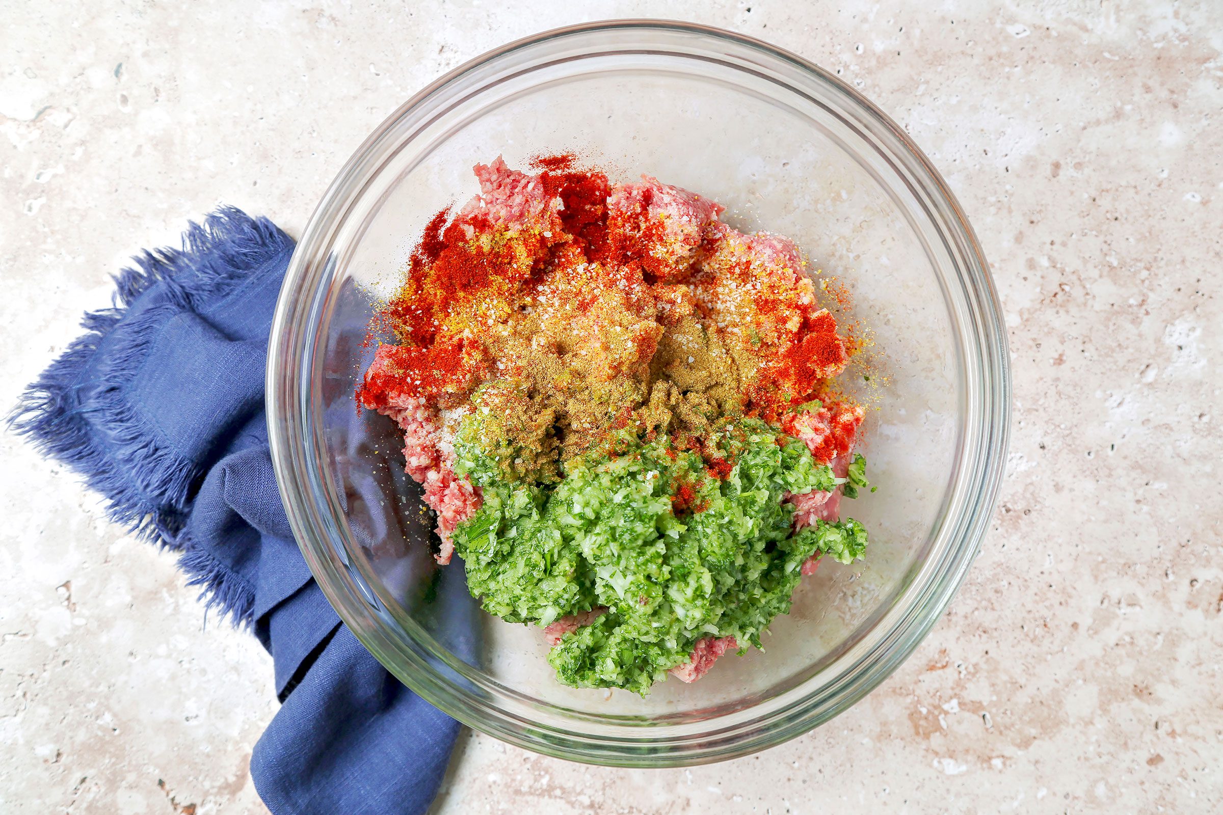 Lemon pepper seasoning, paprika and cumin mixed with minced herbs mixture in a large bowl