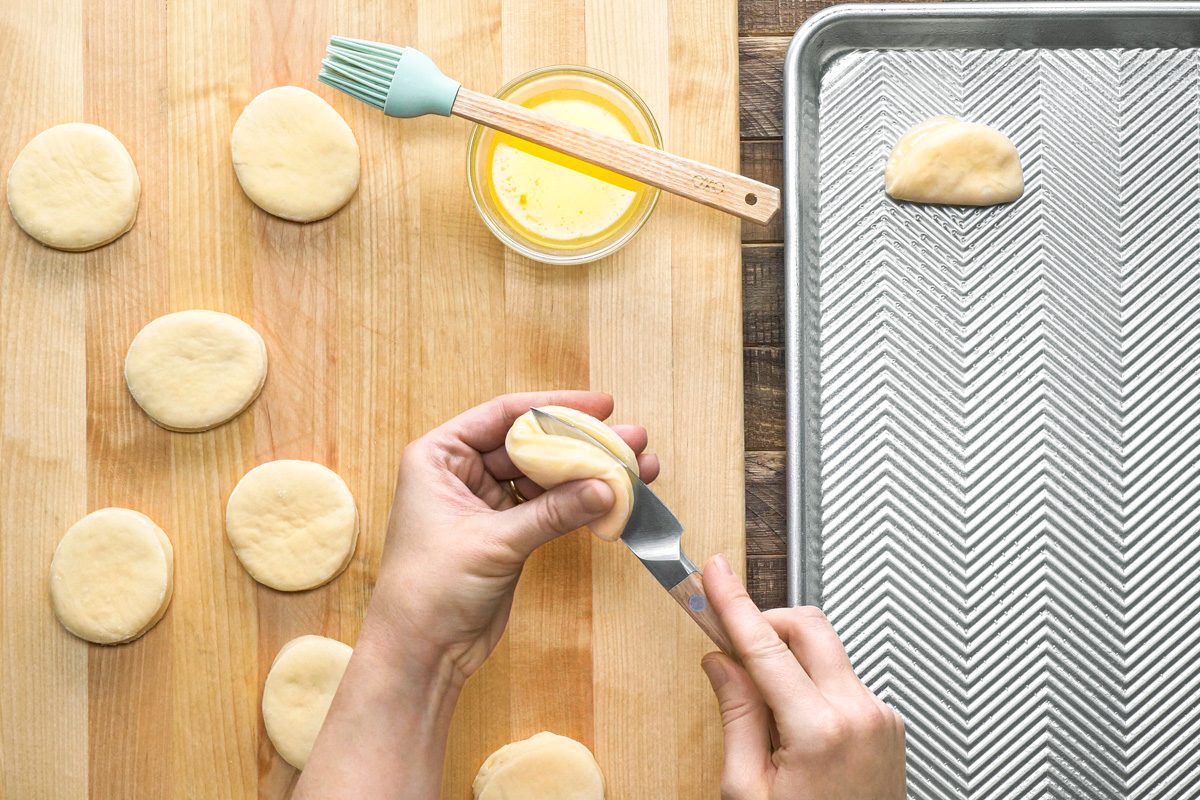 dull edge of a knife being used to crease dough portions