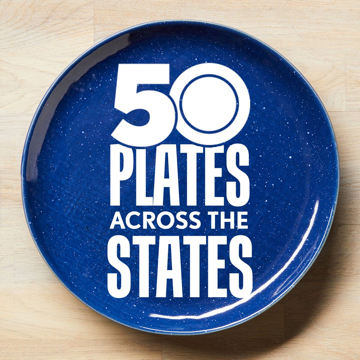 50 Plates Across The States Logo on a blue plate on a light wood surface