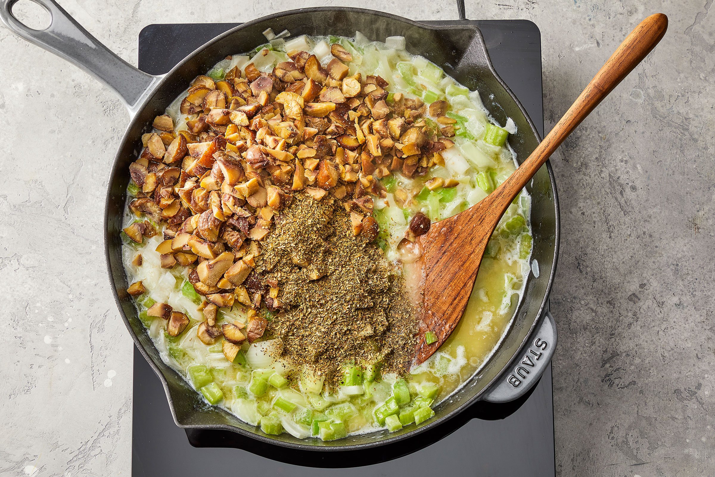 Chestnuts and italian seasoning on celery and onions in a large skillet