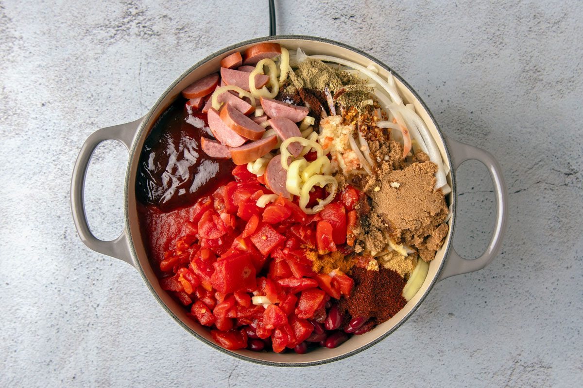 overhead shot of a pot filled with ingredients for chili, the pot is sitting on a light gray counter with gray specks