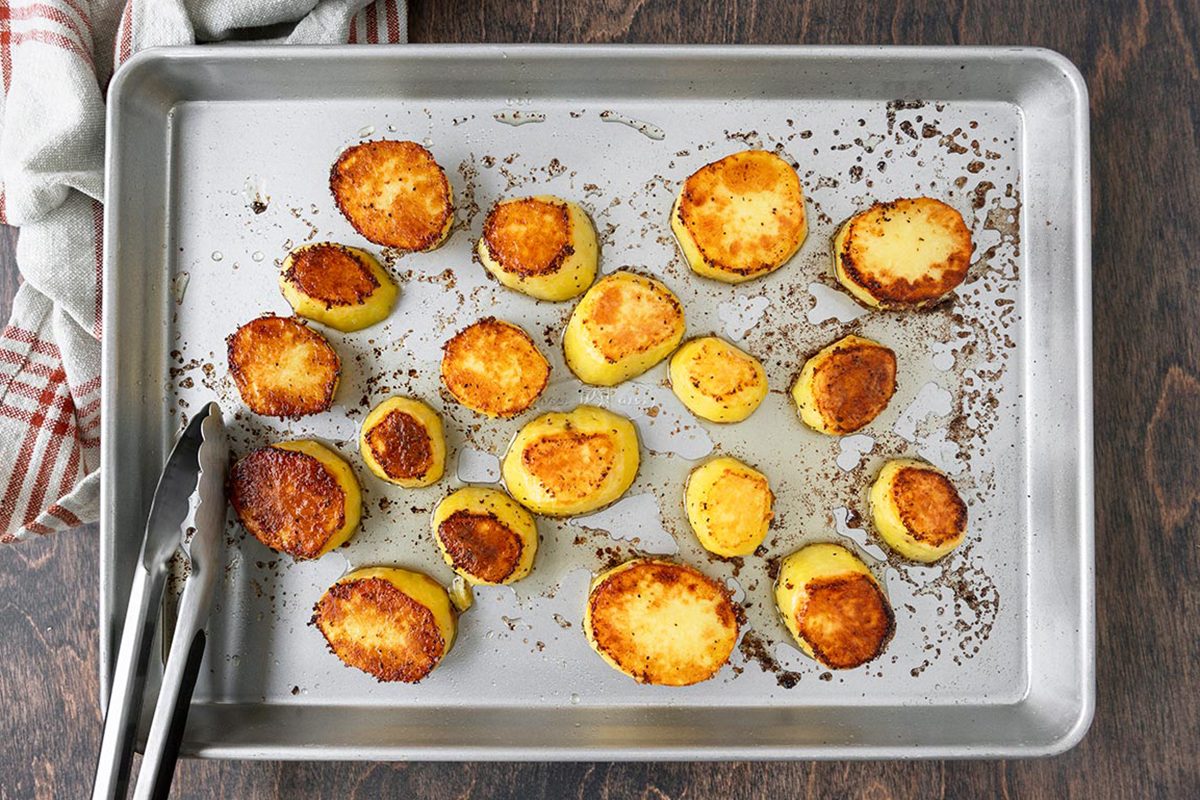 Half roasted potatoes placed on baking tray