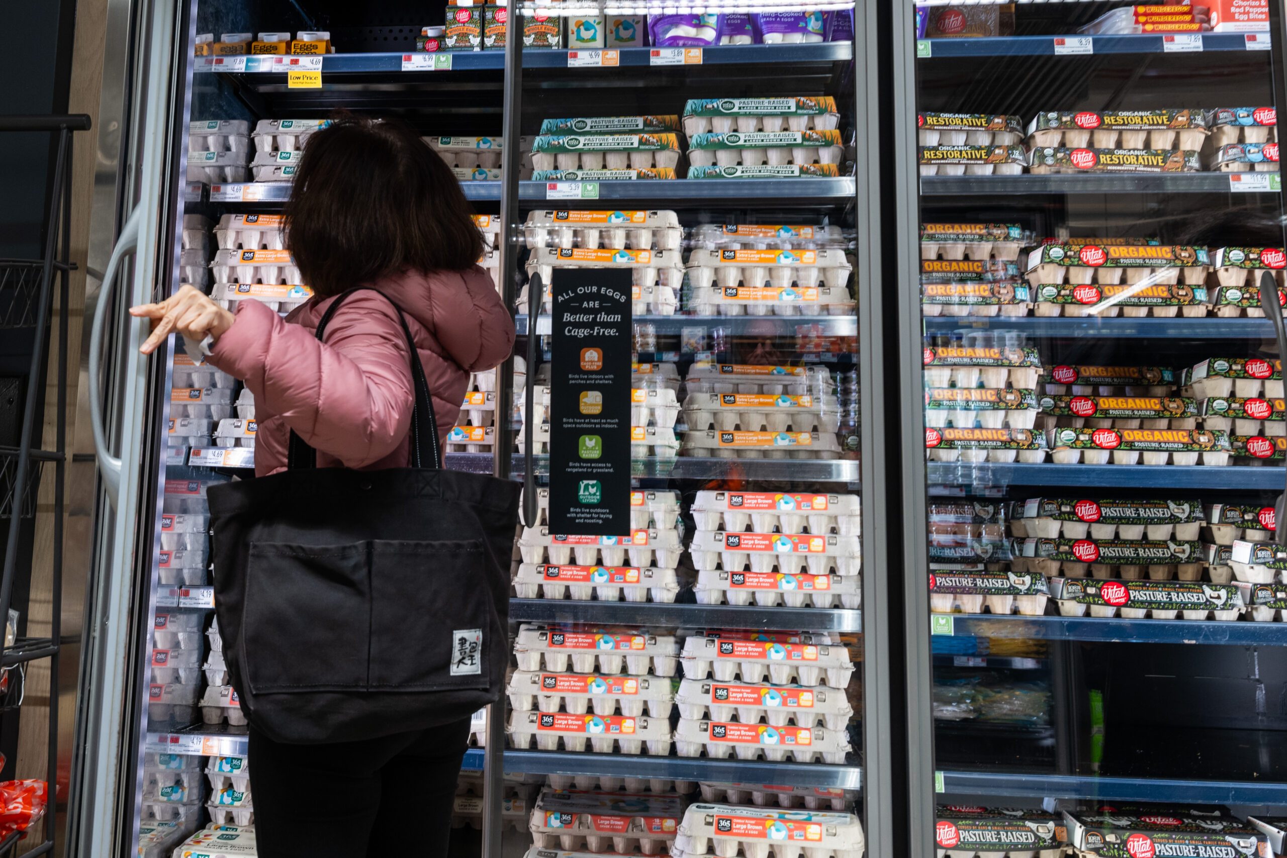 Customer browses the egg refrigerators at Whole Foods