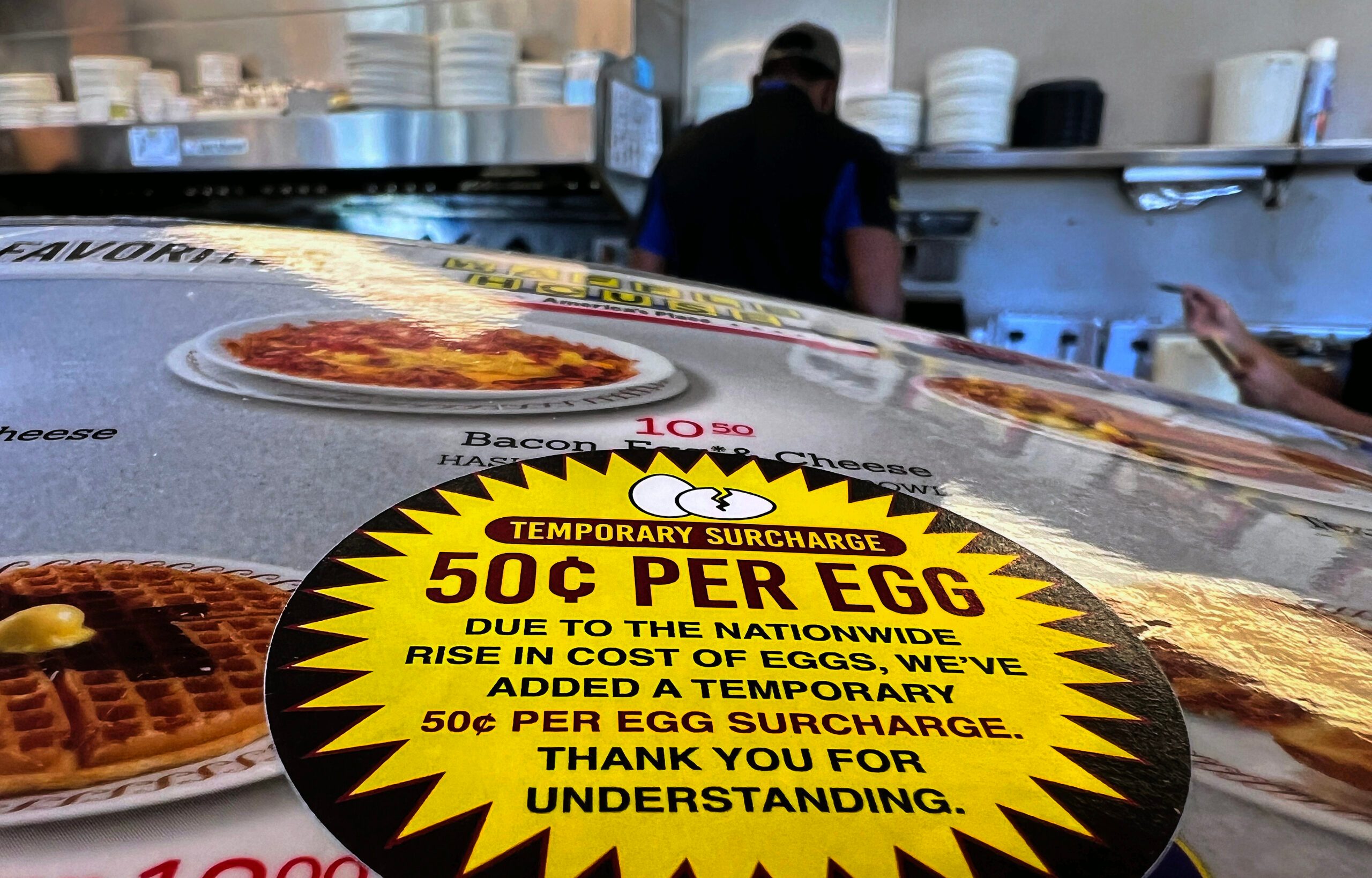 Sticker that says "50 cents per egg" on a Waffle House menu