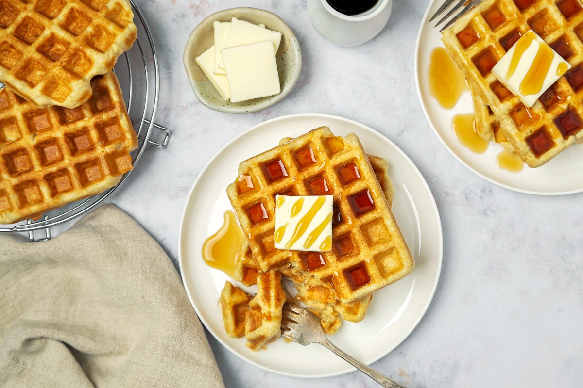 Top view of gluten Free Waffles served on a plate with butter and maple syrup
