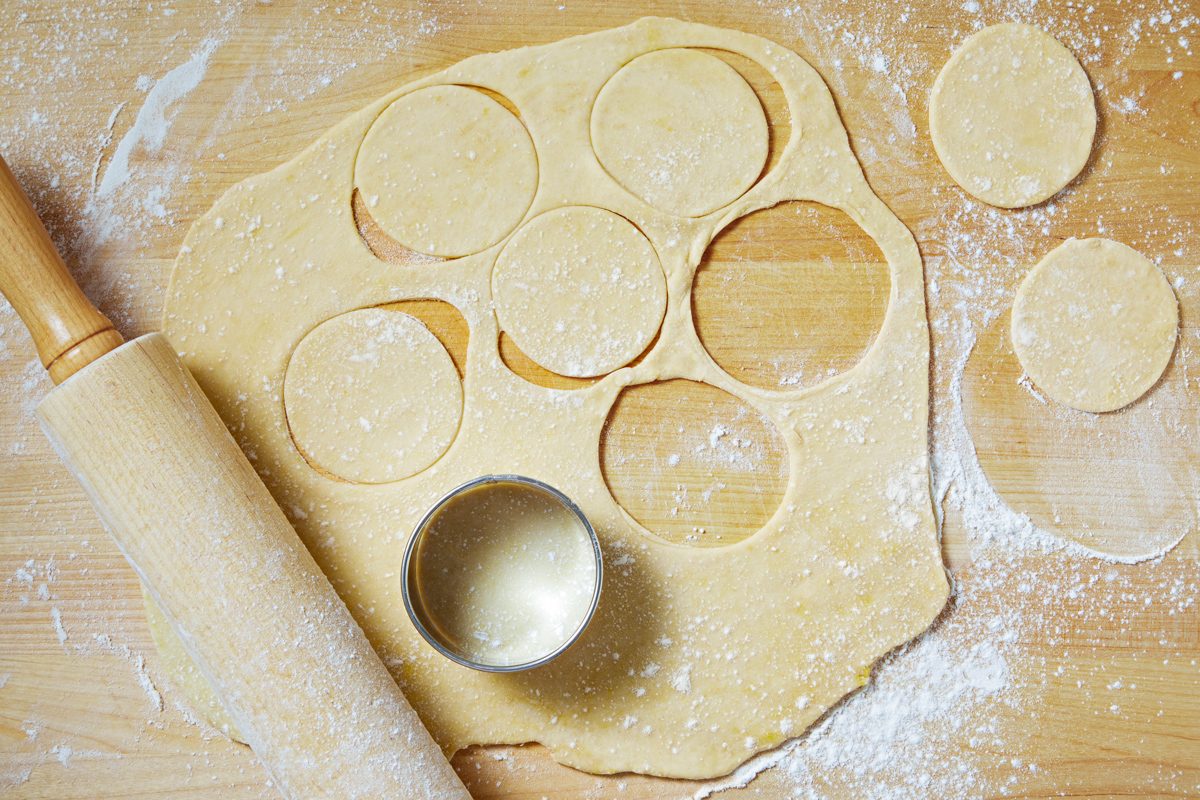cutting dough in circles with biscuit cutter