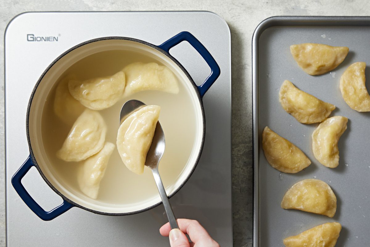 pierogis being boiled in a dutch oven