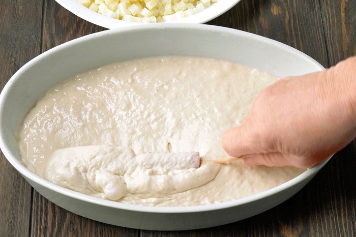 Roll each hot dog and cheese skewer into the batter, covering all sides