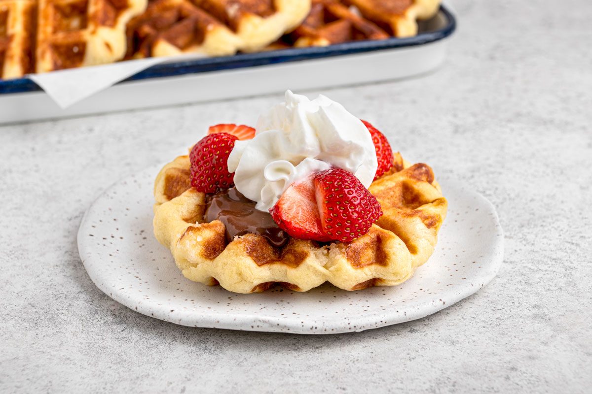 Close shot of Liege Waffles topped with cream and fresh berries