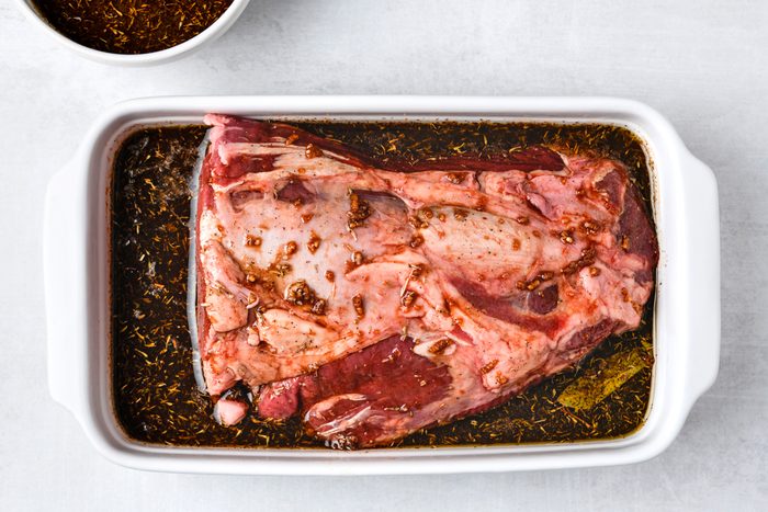 bay leaf and tenderloin added to marinade in a shallow dish