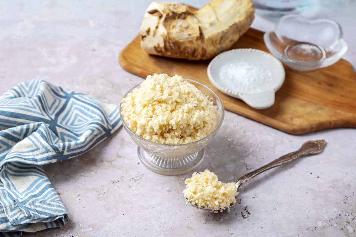 Table view shot of Homemade Horseradish; serve in glass bowl with spoon; wooden tray; napkin; marble surface;