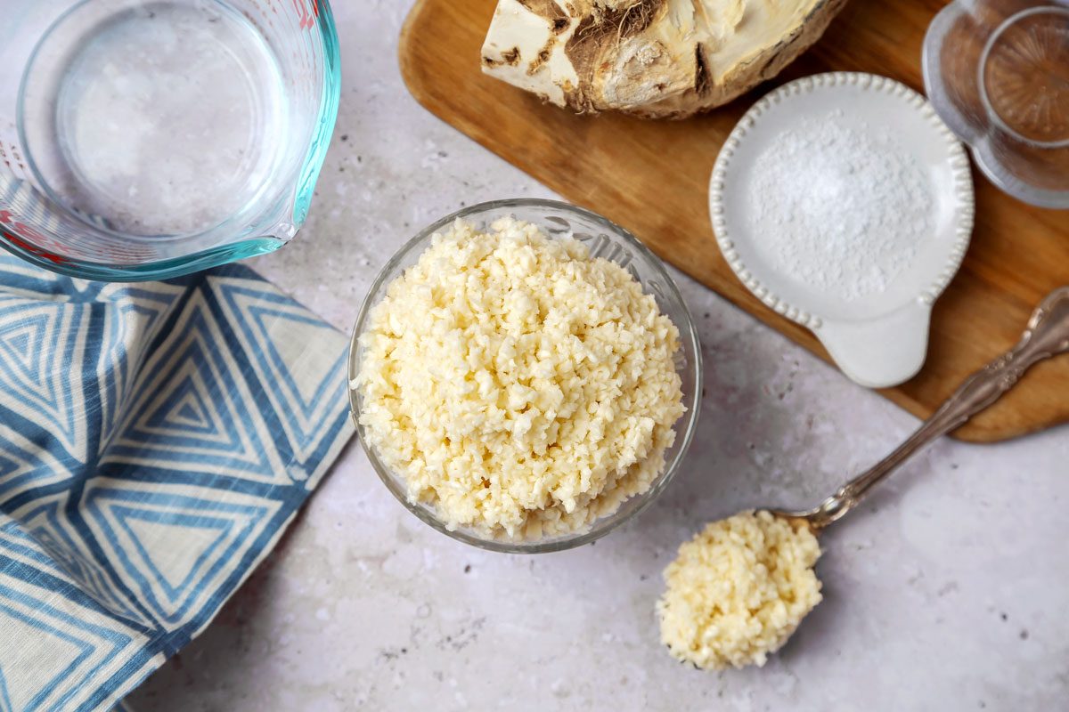 Overhead shot of Homemade Horseradish; serve in glass bowl with spoon; wooden tray; napkin; marble surface;
