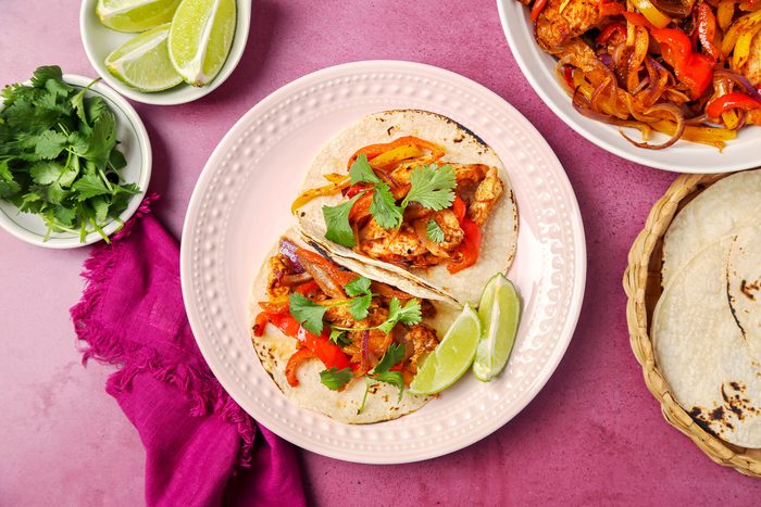 Chicken Fajitas served on tortillas on a pink plate; overhead
