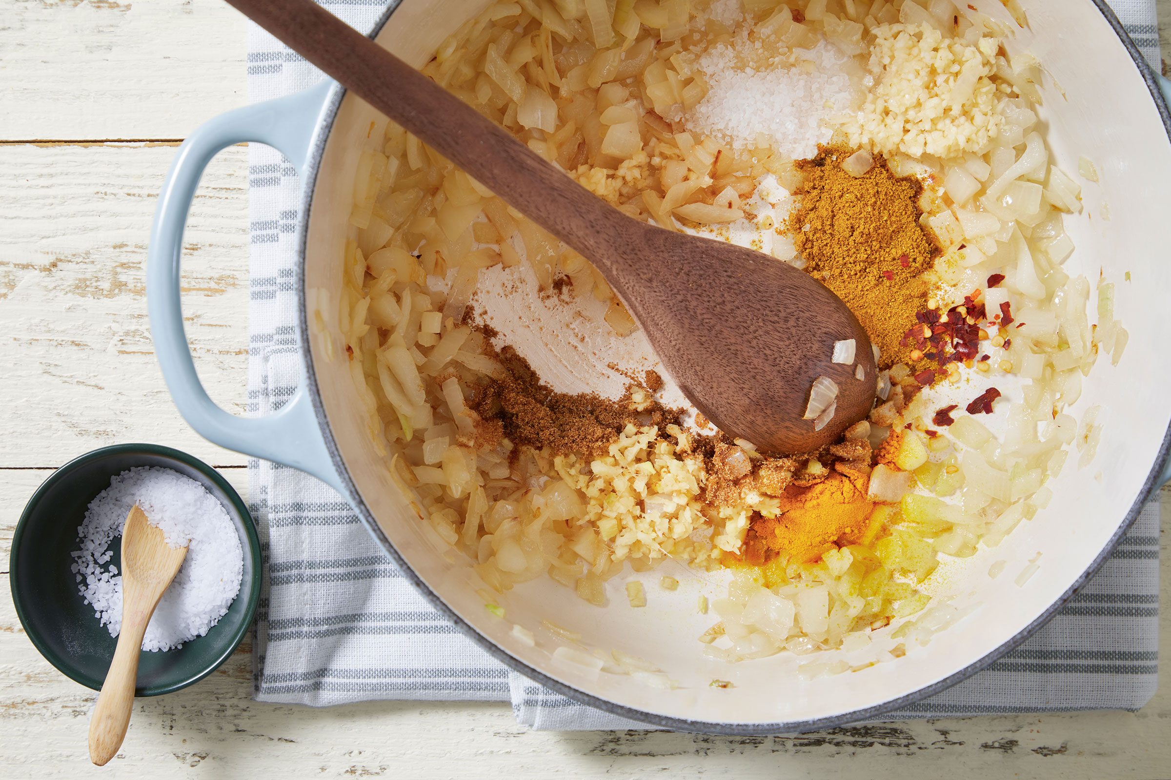 Spices added to cooked onions in a Dutch oven