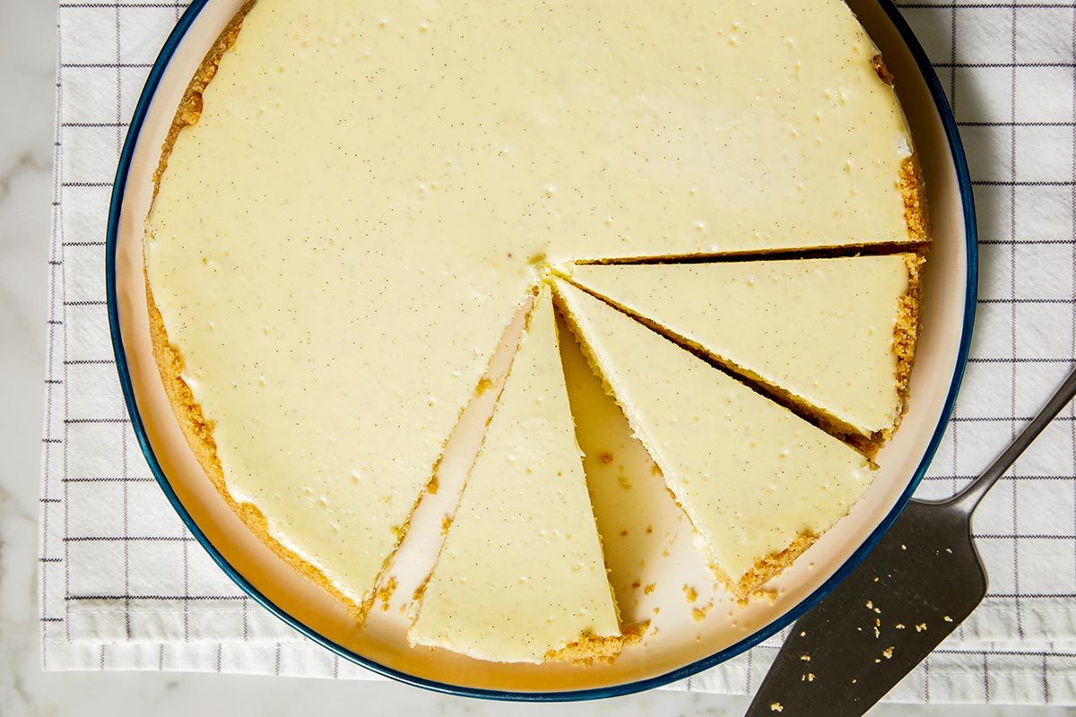 Vanilla bean cheesecake with slices cut, placed on a plate.