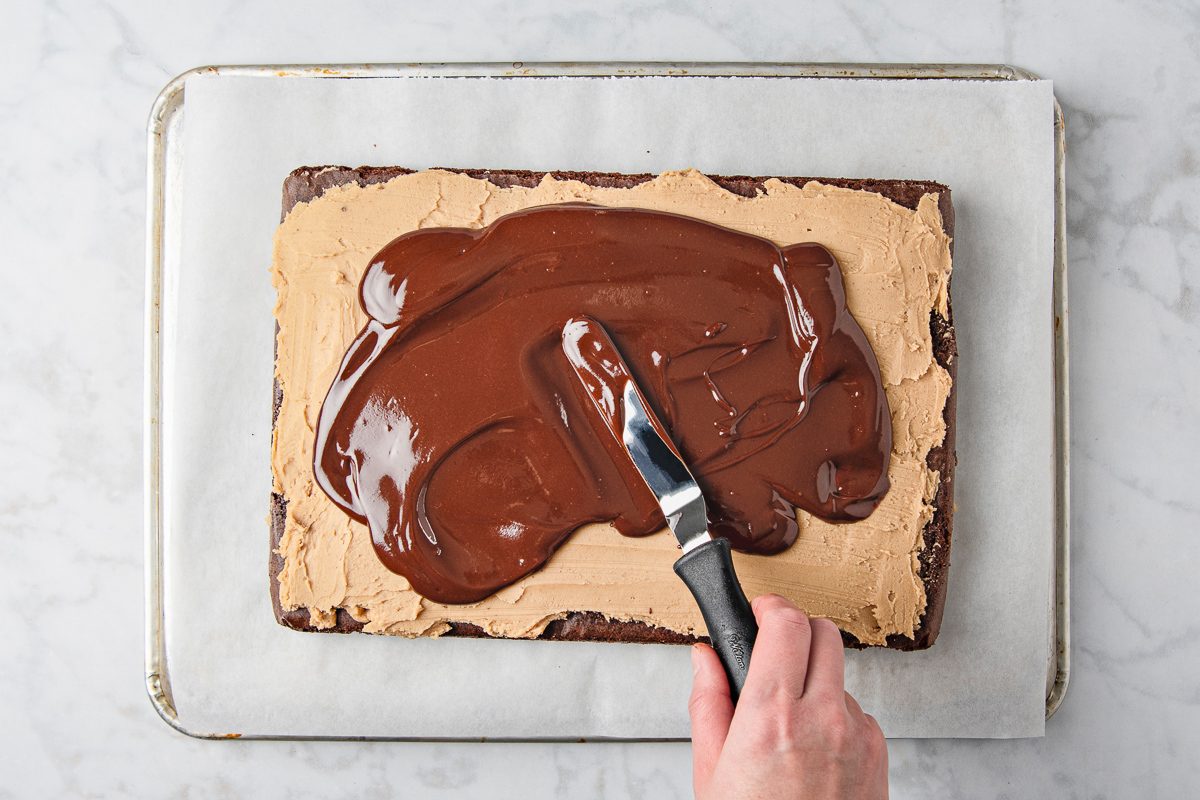 spreading chocolate mixture over brownies