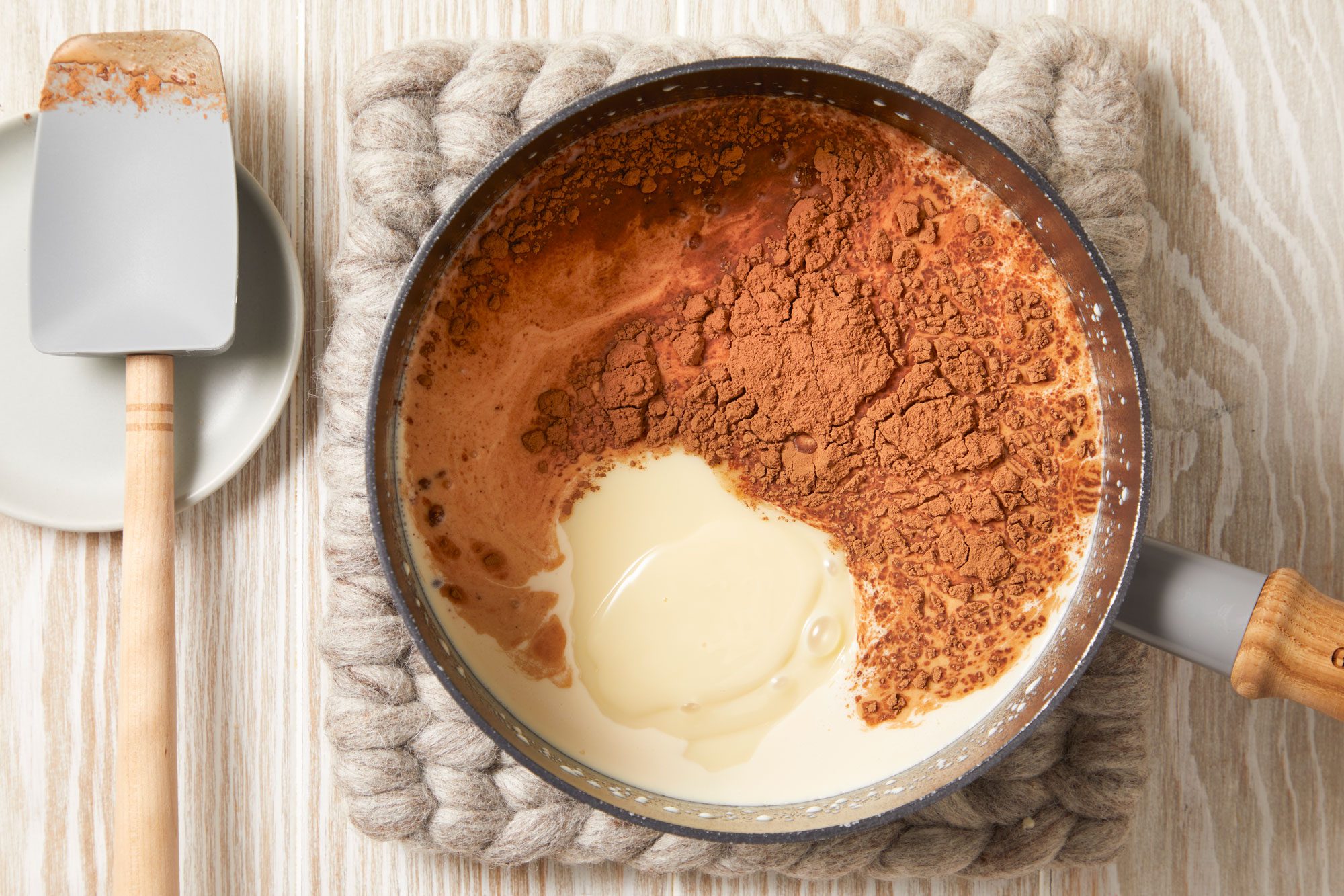 In a large saucepan, combine the condensed milk, evaporated milk, whole milk and cocoa powder.