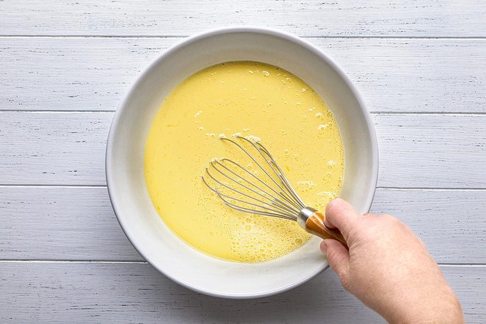 Egg and milk being mixed in a large bowl