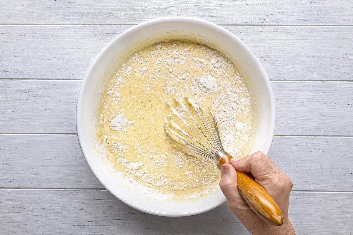 flour, sugar, vanilla and salt being mixed in a large bowl.