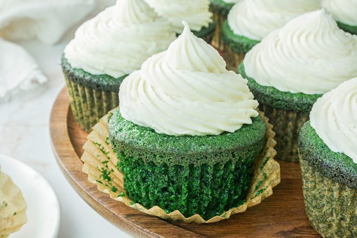 Plated Green Velvet Cupcakes on Marble surface.