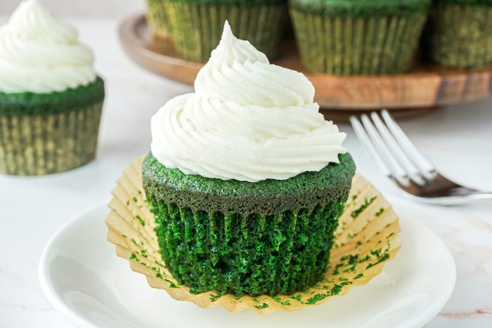 Plated Green Velvet Cupcakes on Marble surface.