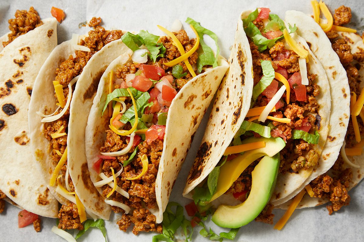 overhead shot of Ground Turkey Tacos, showcasing several soft tortillas filled with a savory mixture of ground turkey